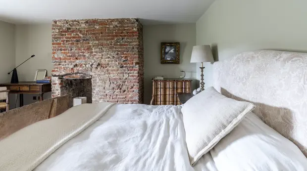 Bedroom with exposed brick wall and bed